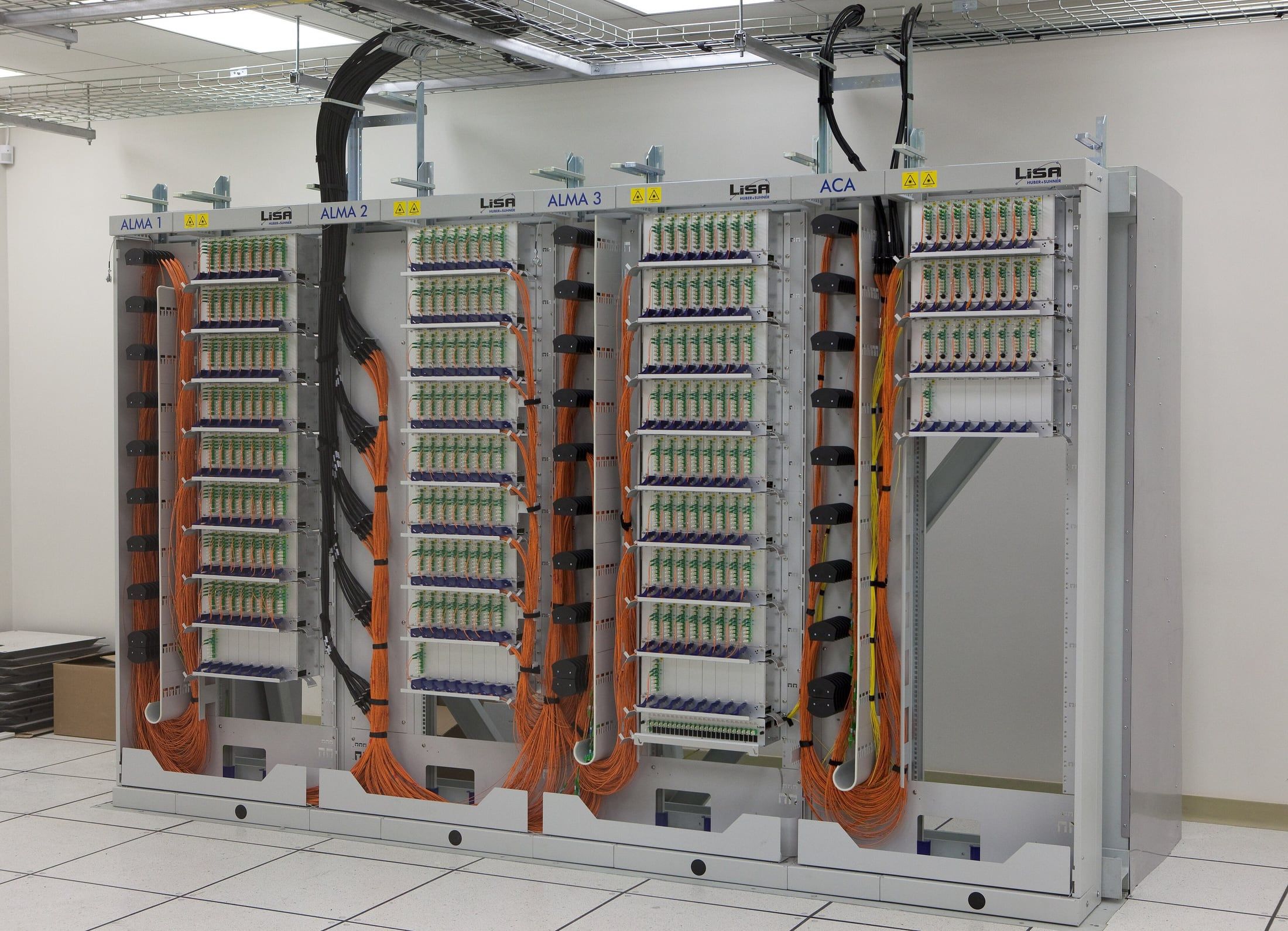 Rows of fibre optic patch panels with dense orange cabling.